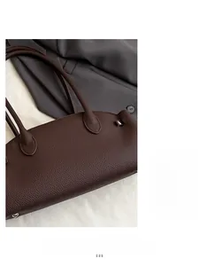 Detail of dark brown lychee pattern leather bag with reinforced handle stitching