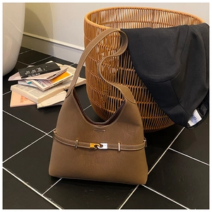 Close-up of the brown lychee textured leather tote bag with gold metal buckle detail