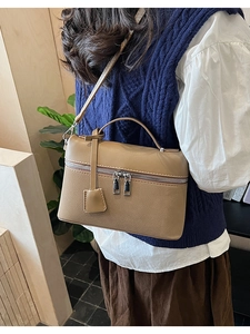 Litchi texture leather crossbody bag shown on model in cozy home interior setting