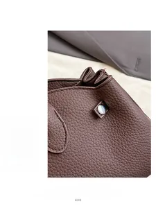 Detailed macro view of brown lychee grain leather texture and metallic buckle fastener