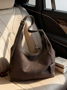 Deep brown large Hobo shoulder bag in matte leather on a luxury car seat