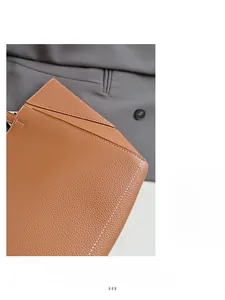 Close-up of brown lychee grain leather handbag with white contrast stitching detail