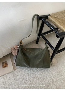 Détail du grand sac bandoulière rétro vert olive avec breloque d'ours en peluche