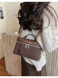 Detail of dark brown matte leather box bag with silver zippers shown on model