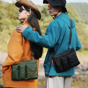 Détail de sac bandoulière tactique extérieur avec poches multiples en vert et noir