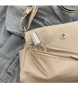 Detailed close-up of a khaki crossbody bag featuring a practical front zipper pocket