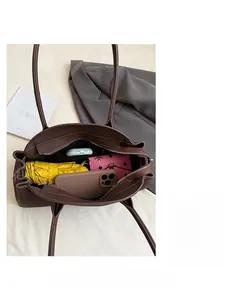 Top view of spacious interior in a brown leather tote bag with daily essentials inside