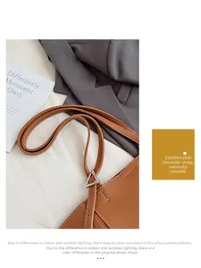 Detail of brown lychee leather shoulder strap with white stitching and silver hardware