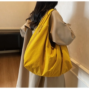Back view of model wearing a bright yellow oversized nylon tote bag for commuting