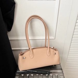 Detail view of beige pebbled leather baguette bag with side pleats and silver hardware
