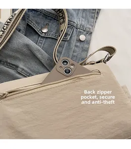 Detail of the beige crossbody bag featuring a secure back zipper pocket for a smartphone