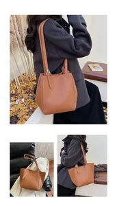 Detail of brown pebbled leather tote bag with white contrast stitching and metal buckle