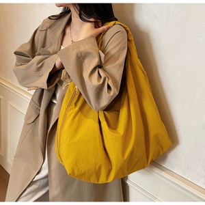 Detail of a large yellow canvas tote bag with zipper closure for casual daily use
