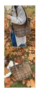 Close-up of brown plaid wool tote bag with artistic embroidery shown in autumn setting