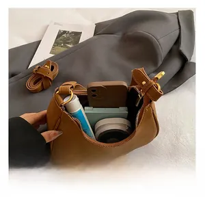 Detailed interior of brown lychee grain crescent bag showing storage space for cosmetics