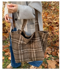 Detail of vintage brown plaid tote bag with letter embroidery and slim shoulder straps
