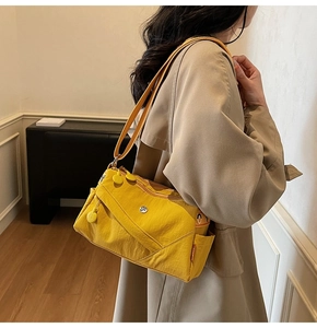 Side view of bright yellow nylon crossbody bag with multi-pocket design on model