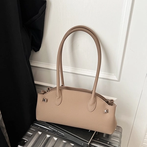 Detail of beige litchi grain leather shoulder bag with silver hardware and wavy edge