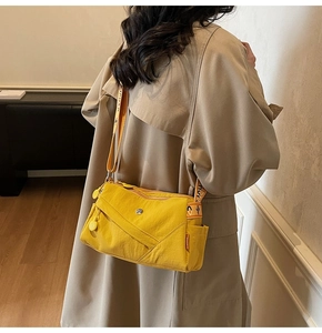 Close-up of a bright yellow nylon crossbody bag with multi-pocket design and fashion strap