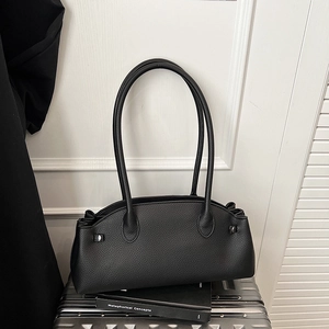Close-up of black litchi pattern leather texture on a stylish baguette handbag