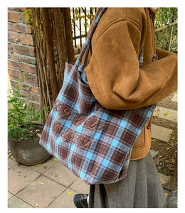 Detailed embroidery on vintage plaid canvas tote bag with autumn fashion styling