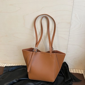 Detail of camel leather tote bag showing white stitching and silver triangle buckle