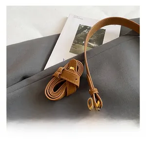 Detail of brown PU leather shoulder bag with adjustable strap and plush bear pendant