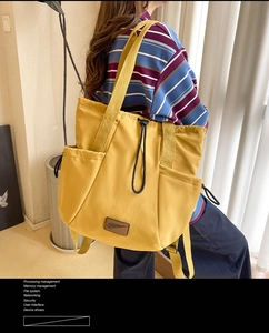 Macro detail of mustard yellow waterproof nylon tote showing drawstring and side pocket