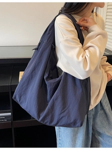 Large navy blue casual canvas tote bag with drawstring detail shown on a model