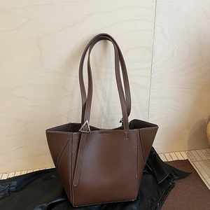 Close-up of litchi grain brown tote bag featuring a silver triangle metal buckle detail