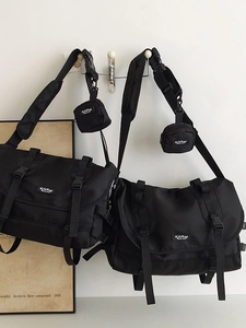Large black nylon messenger bag with multi-pocket design and small accessory pouch