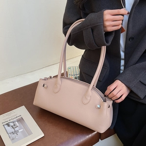 Detail of light pink lychee leather bag featuring silver hardware and side pleats