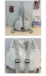 Detail view of cream nylon drawstring backpack with adjustable straps and side pockets