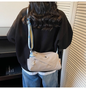 Detail showing the adjustable blue jacquard strap and pockets on the casual crossbody bag