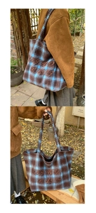 Macro shot of blue and brown checkered tote bag with embroidered letters and thick fabric