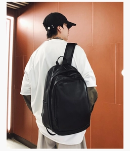 Rear view of model wearing a large black soft leather waterproof backpack for commute