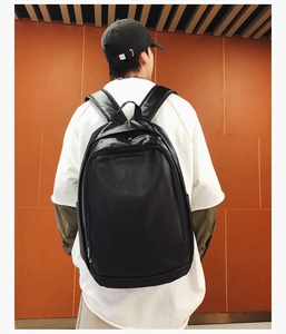 Detailed back view of a minimalist black soft leather backpack with wide straps