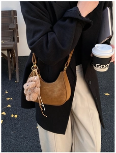 Brown frosted crescent shoulder bag featuring a cute plush bear charm and gold logo