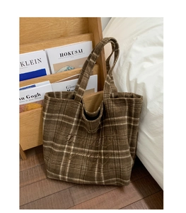 Detail view of vintage brown plaid tote bag featuring elegant cursive embroidery