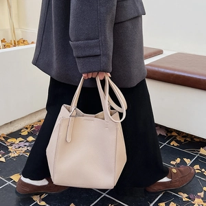 Detail of off-white lychee grain tote bag with polygonal bucket design and long handles