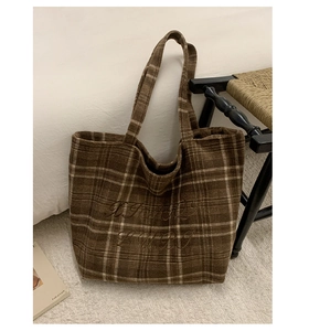 Detailed embroidery and vintage plaid wool texture on a stylish large shoulder tote bag