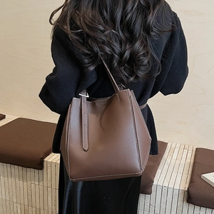 Detailed view of brown lychee grain tote bag with contrast stitching and metal side buckle