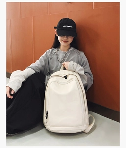 Detail showing creamy white waterproof backpack with smooth zipper and minimalist design