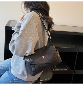Detail of black crossbody bag with SJCHAO printed canvas wide shoulder strap and side pocket