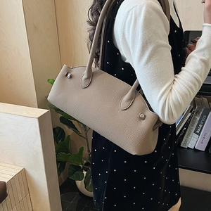 Detailed close-up of taupe litchi grain leather shoulder bag with metallic rivets