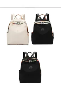 Three stylish Oxford cloth backpacks shown in beige, black, and patterned embroidery