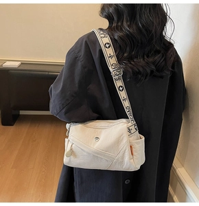 Detail of cream nylon crossbody bag with multi-zipper layers and wide printed strap