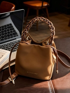 Fashionable brown bucket bag with a woven handle and adjustable crossbody strap
