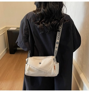 Detail of beige nylon crossbody bag featuring wide jacquard shoulder strap with floral patterns
