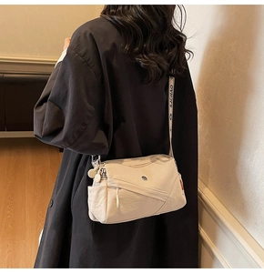 Detail of cream nylon crossbody bag with multi-pocket structure and jacquard logo strap